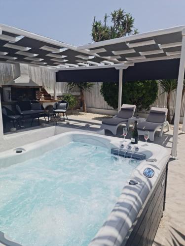 a swimming pool with a patio with chairs and an umbrella at Zoumis Residence in Naousa