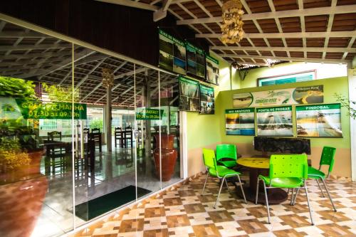 a dining room with a table and green chairs at Pousada e Hostel Coração Verde, Vários Tipos de Acomodações 300 metros da Orla in Alter do Chao