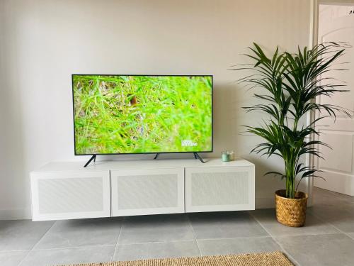 a television sitting on a white entertainment center in a living room at Torres Beach in Arona