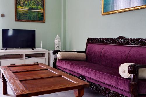 a living room with a purple couch and a table at Vintage country house in Halkidiki in Nea Fokea