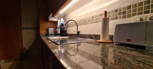 a kitchen with a sink and a counter top at An apartment by the sea in Oliva Playa in Oliva