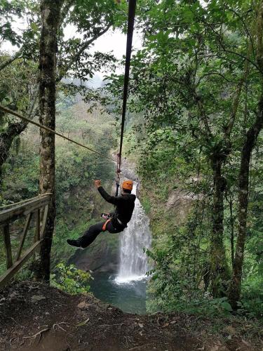 a person on a rope swing over a waterfall at Hotel Hacienda San Bartolo in Xico