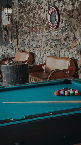 a pool table with balls in front of a stone wall at Hotel Hacienda San Bartolo in Xico