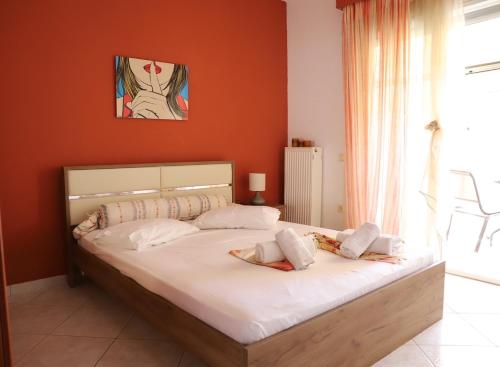 um quarto com uma cama grande e lençóis brancos em EKALI em Nea Peramos