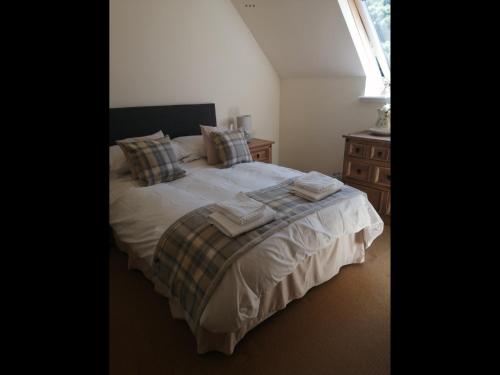 a bedroom with a bed with towels on it at No4 Millhouse Flats in Inverlochy