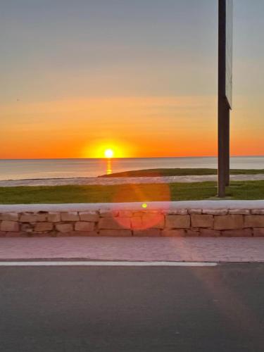 una puesta de sol en la playa con el océano y una calle en Tamuda Bay- Alcudia Smir - Fnideq en Fnidek