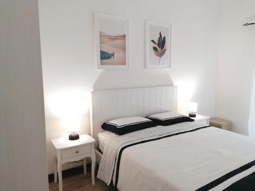 1 dormitorio con 1 cama blanca y 2 almohadas en B in Caminha, en Caminha