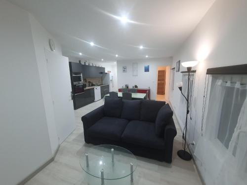 un salon avec un canapé et une table en verre dans l'établissement Au coeur Normand Magnifique maison avec jacuzzi 25mn de la mer, à Audrieu