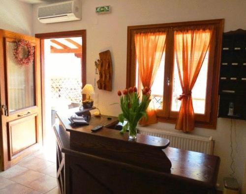 eine Küche mit einem Schreibtisch und einer Blumenvase darauf in der Unterkunft Ikosimo Guesthouse in Milína