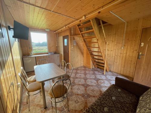 a room with a table and a staircase in a cabin at Domki letniskowe Wiciowa 7 in Wicie