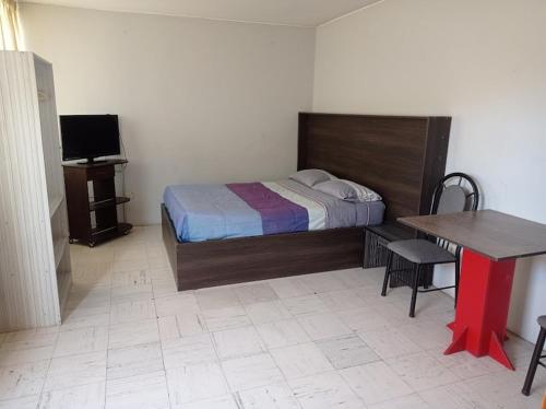 - une chambre avec un lit, une table et un bureau dans l'établissement Luxor, à Arequipa