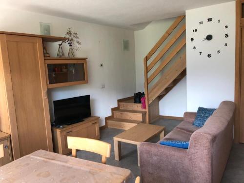 a living room with a staircase and a couch and a table at Casa dell'Olivo in Castione Andevenno