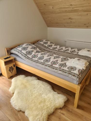 a bedroom with a bed with a white rug on the floor at Apartamenty w cichej okolicy in Bańska Wyżna