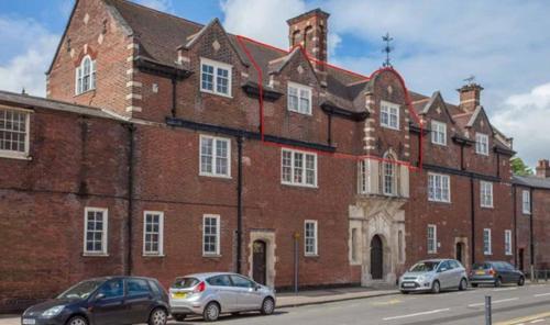 a large brick building with cars parked in front of it at Stylish -2 Bed -Heart of the City - Parking- Wi-fi- Award Winning- Grade II Listed in Norwich
