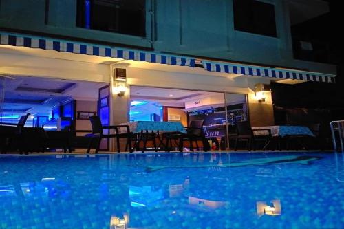 a large swimming pool with chairs and a table at Livane Sun Otel in Alanya