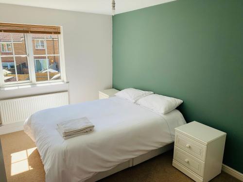 Un dormitorio con una gran cama blanca y una ventana. en Mezzo House- Entire property, en Coventry