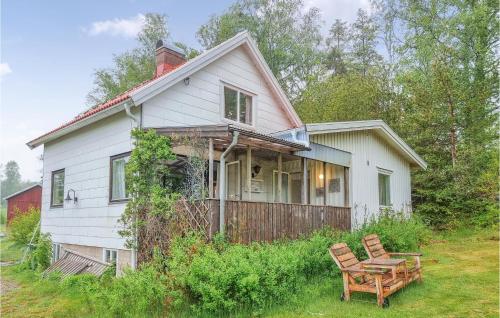 a white house with two chairs in the yard at 3 Bedroom Gorgeous Home In Tanumshede in Tanumshede