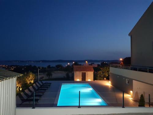 uma piscina no telhado de uma casa à noite em Villa Visum em Zadar