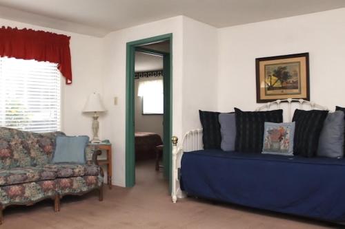 a bedroom with a bed and a couch and a mirror at Piety Hill Cottages in Nevada City
