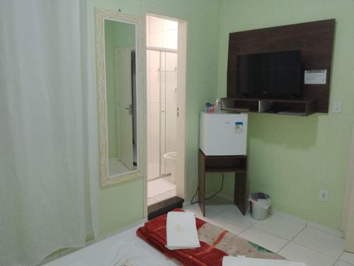 a room with a bathroom with a tv and a mirror at Pousada Souza Castro in Ouro Preto