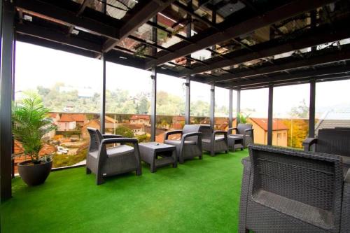 eine Gruppe Stühle auf einem Balkon mit grünem Gras in der Unterkunft Premium Residence in Braşov
