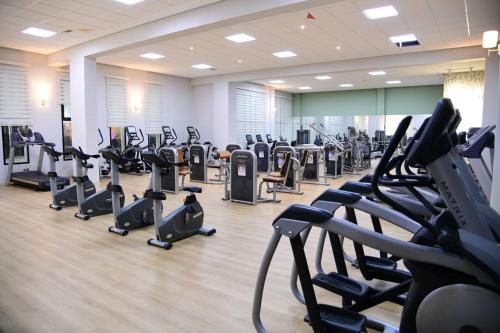 a gym with rows of treadmills and elliptical machines at Eventi Club by cité des sports adarissa in Fès