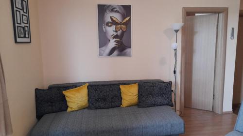 sala de estar con sofá y almohadas amarillas en Sunny Days apartman Kopaonik, en Kopaonik