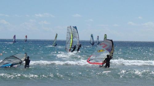 a group of people windsurfing in the ocean at Caparica Sun Centre in Costa da Caparica