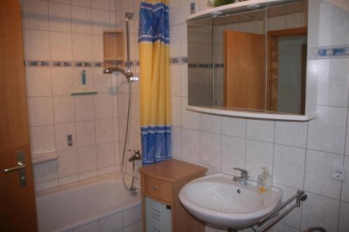 ein Badezimmer mit einem Waschbecken, einer Badewanne und einer Dusche in der Unterkunft Apartment Schinkmann in Bad Frankenhausen