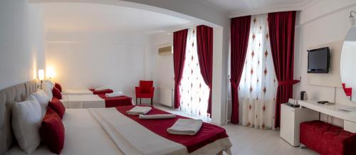 um quarto de hotel com duas camas e uma televisão em Ayapam Hotel em Pamukkale
