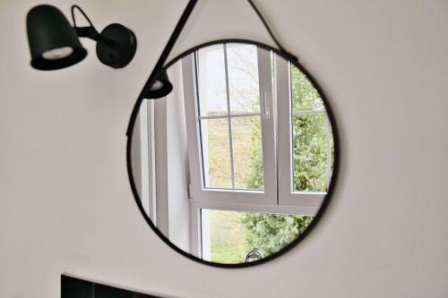 a mirror in a room with a window at Mein Eifel Ferienhaus Altes Pfarrhaus in Dahlem