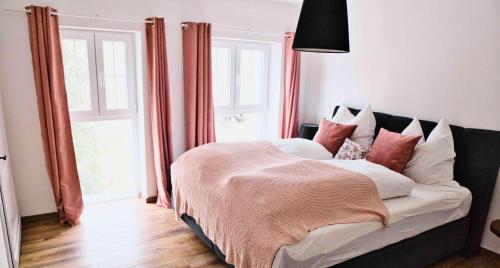 a bedroom with a large bed with red and white pillows at Mein Eifel Ferienhaus Altes Pfarrhaus in Dahlem