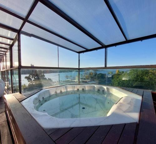 a large jacuzzi tub in a room with windows at Costalago Suites- By HVH in Villa Carlos Paz