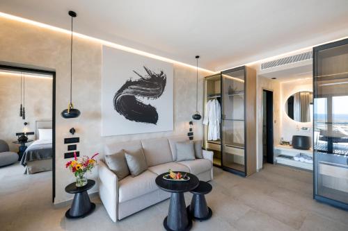 a living room with a couch and tables and a bed at Tropicana Hotel , Suites & Villas Mykonos in Paradise Beach