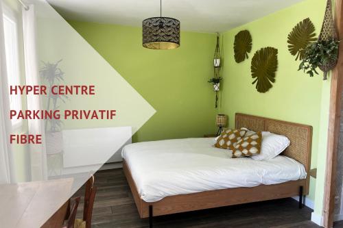 um pequeno quarto com uma cama e paredes verdes em ver(t) chez nous em Périgueux
