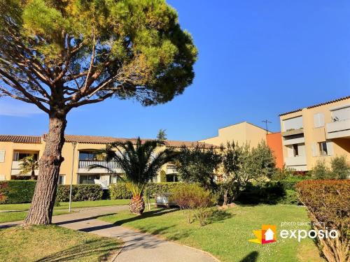un parc avec un arbre et un bâtiment dans l'établissement Le Pin Parasol à Cassis - Studio 3 personnes by K6, à Cassis