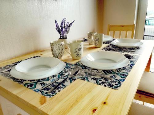 a wooden table with plates and utensils on it at Apartament Janka in Zator