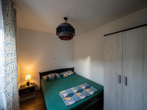 a bedroom with a green bed and a lamp at Arabeska Majeli in Rukavac