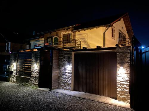 un edificio con garaje por la noche en IGI HOUSE with pool 12 km from Cluj-Napoca, en Gilău