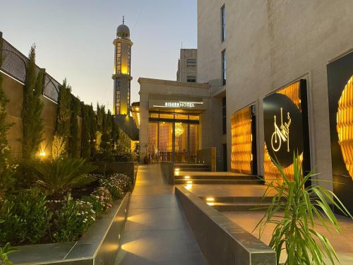 un edificio con una torre de reloj en el fondo en Nishan Hotel, en Amán