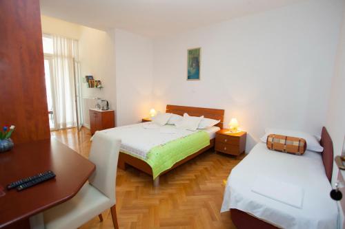 圖策比的住宿－Villa Alesa，小房间设有两张床、一张桌子和一张书桌
