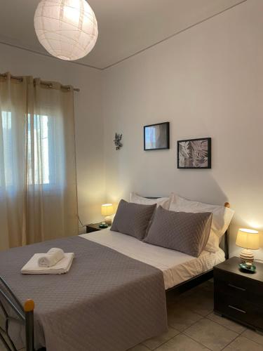 una camera da letto con un grande letto con una coperta bianca di Alexandra's Apartments a Kounoupidhianá