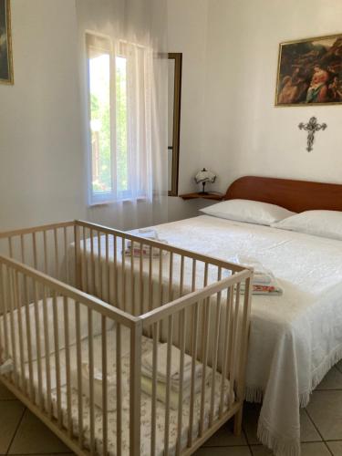 ein Schlafzimmer mit einem weißen Bett und einem Fenster in der Unterkunft Cottage Sara in Castellana Grotte