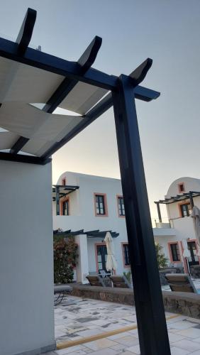 drewniana pergola przed budynkiem w obiekcie Anthonas Apartments w Imerovíglion