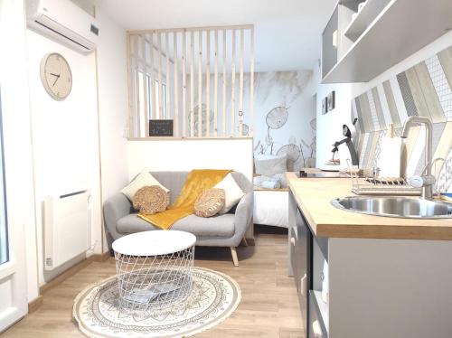 uma cozinha e sala de estar com um sofá e um lavatório em ☆ 16ème ciel ☆ Proche gare ☆ Vue panoramique ☆ Clim. em Toulouse