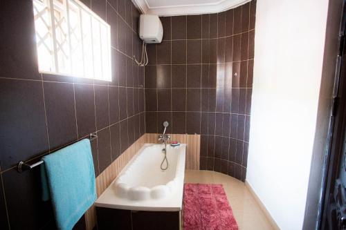 a bathroom with a tub and a pink rug at Accra Luxury Homes @ East Legon in Accra