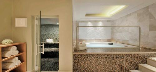 a bathroom with a tub and a walk in shower at Taj Luxury Suite in Cape Town