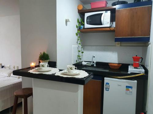 uma cozinha com um balcão com 2 chávenas e um micro-ondas em Flat mobiliado praia, João Pessoa PB PROMOÇÃO em Cabedelo