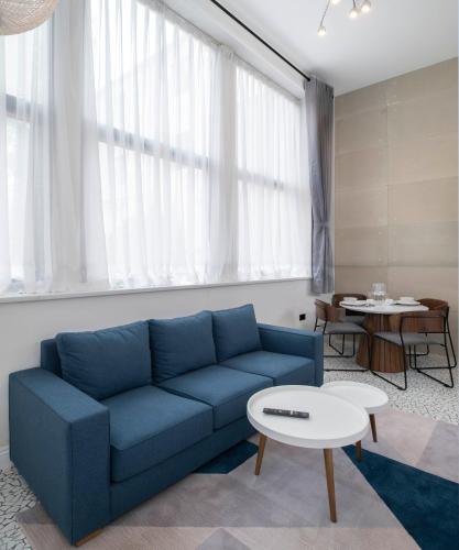 a living room with a blue couch and a table at Trueman Court Luxury Serviced Apartments in Liverpool