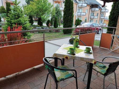 a table and chairs on a balcony with a view of a street at Slnečné apartmány in Podhájska